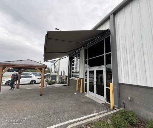 Motorized retractable awning providing shade over outdoor seating